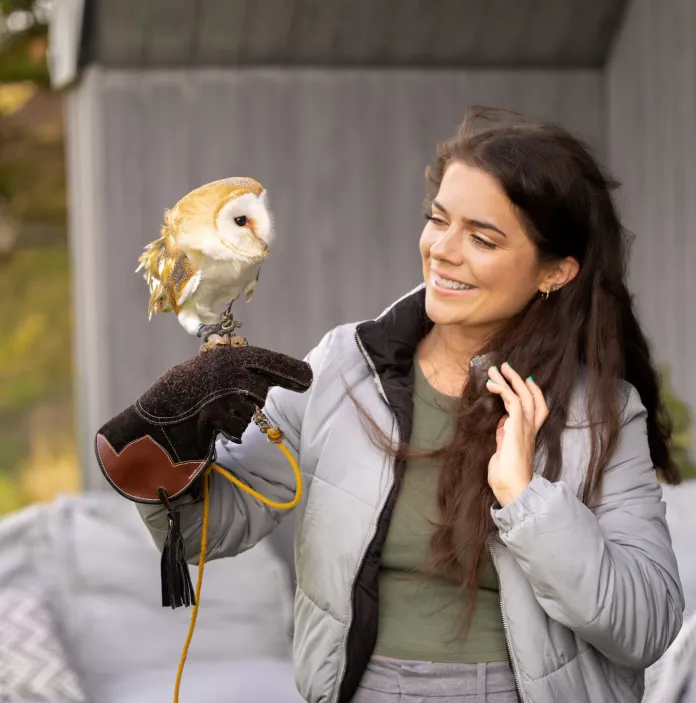 Guest staying at the Rhiw Wood Treehouses and holding an Owl