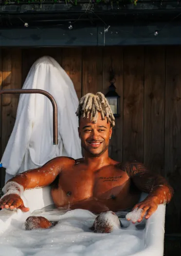 A man enjoying a luxurious retreat at Y Nyth, a turf-roofed cottage near Bleddfa, Mid Wales.