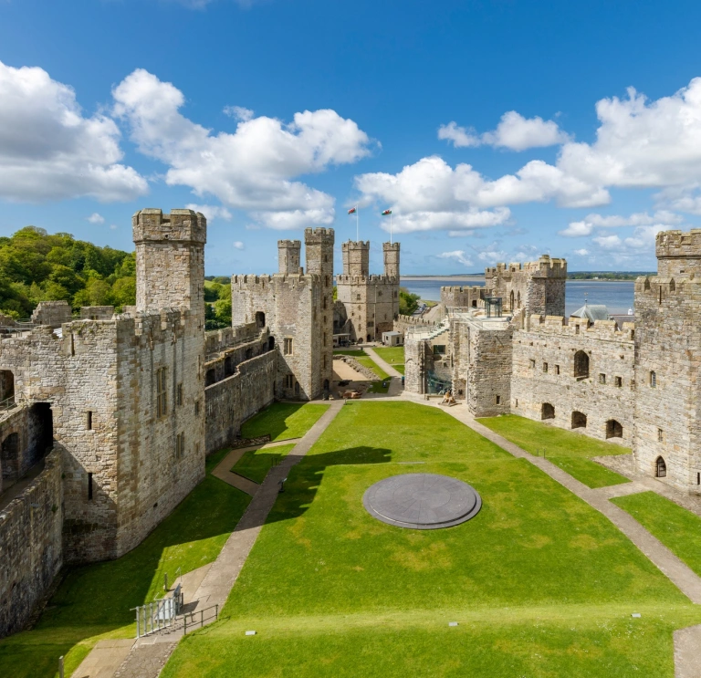 Inside the grounds of a castle with views of the sea beyond.