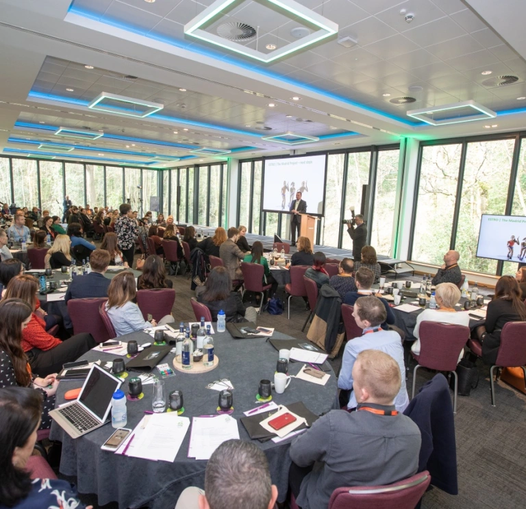 A group of people on a round table at a conference. 
