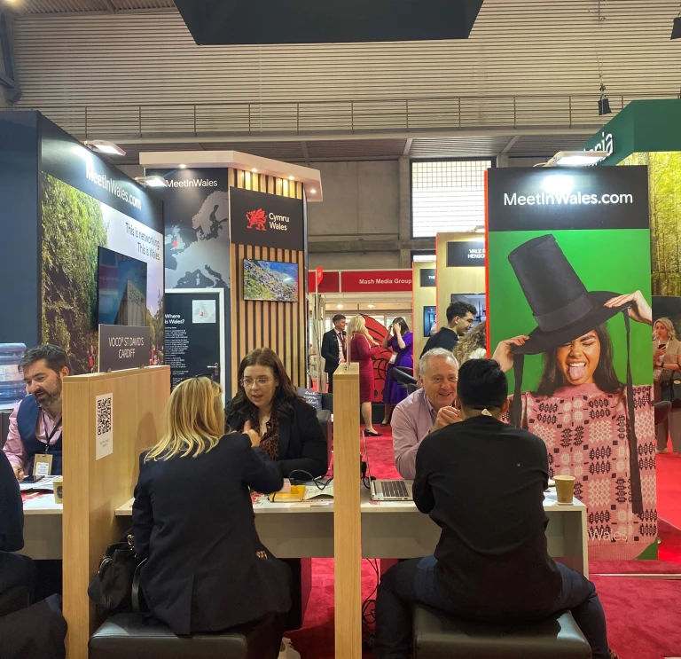 A group of people having a meeting at an exhibition.