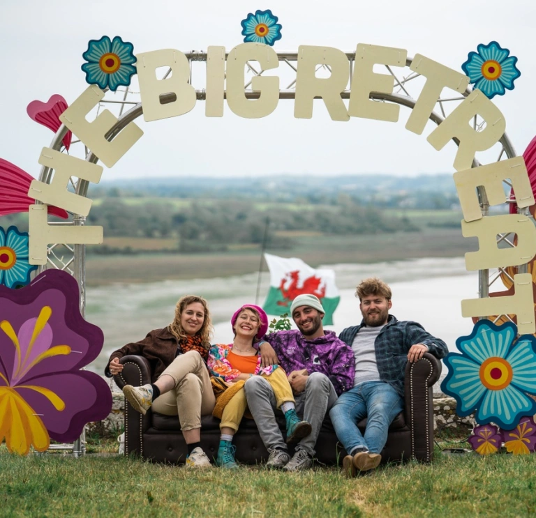 People sat beneath The Big Retreat festival arch