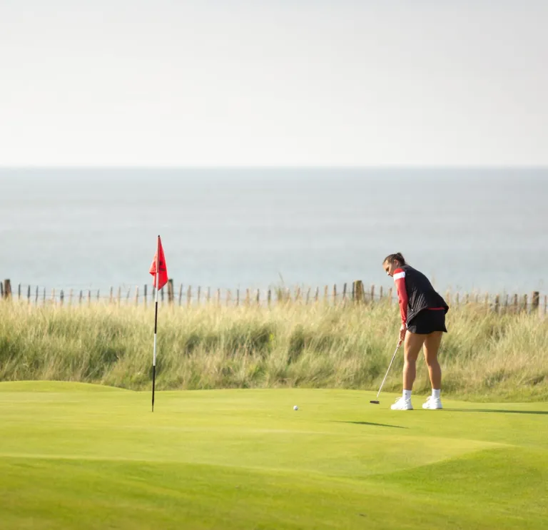 Woman playing golf at the Royal Porthcawl Golf Club South Wales Wales