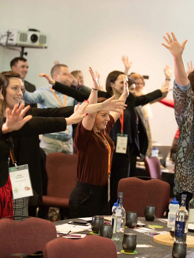 A group of people at a conference taking part in an activity.