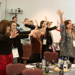 A group of people at a conference taking part in an activity.