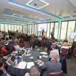 A group of people on a round table at a conference. 