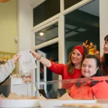 Friends being served Welsh cakes at a bakery store on the Cardiff Food Tour