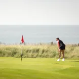 Woman playing golf at the Royal Porthcawl Golf Club South Wales Wales