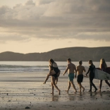 A group of friends doing yoga, enjoying a sauna and cold water swimming at Newgale beach, Pembrokeshire.