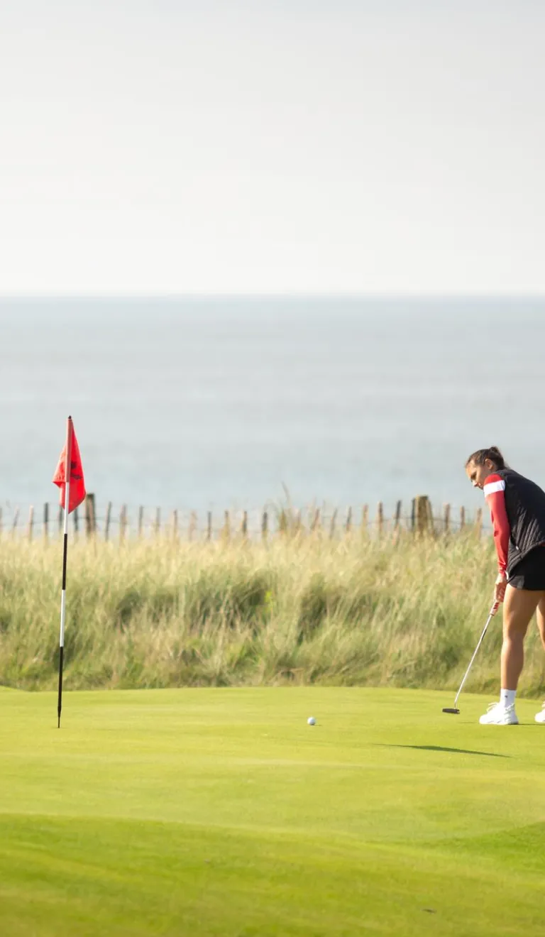 Woman playing golf at the Royal Porthcawl Golf Club South Wales Wales